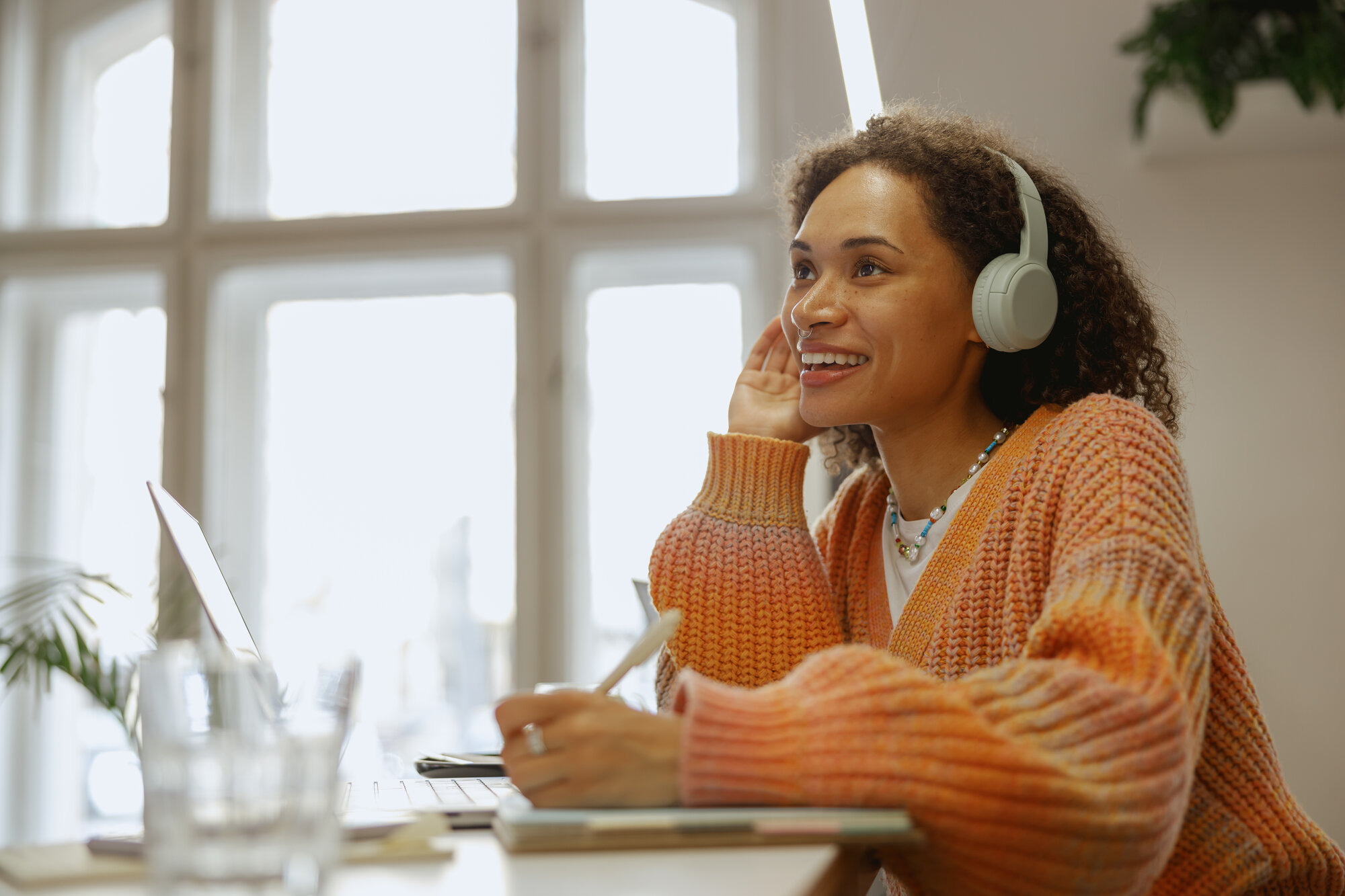 smiling woman wearing headphones with laptop at ho 2026 01 09 10 03 04 utc